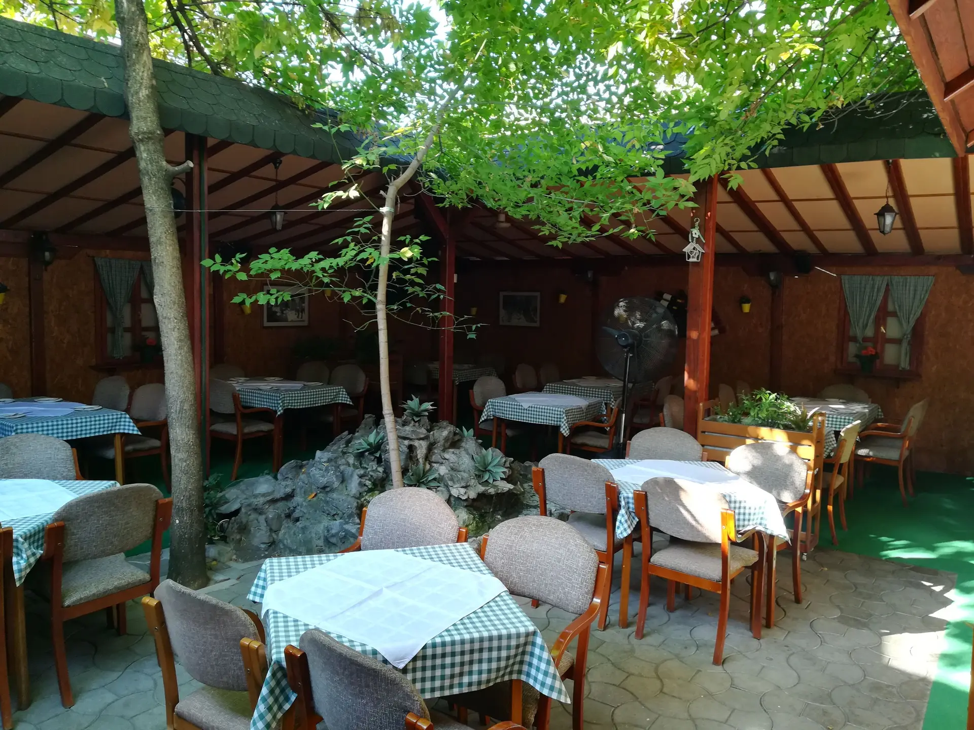 Letnja bašta restorana Morava u hladu drveća, sa malom fontanom