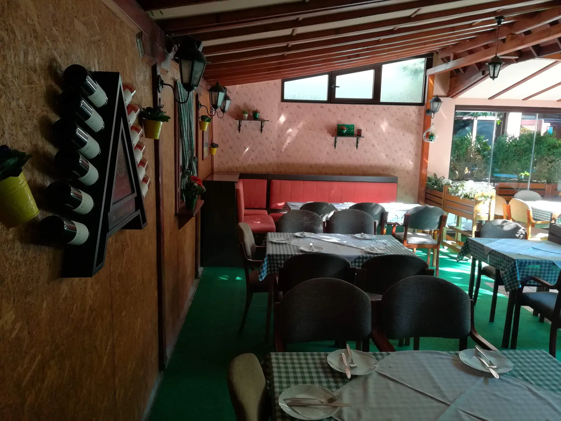Kutak bašte sa stalkom za vino i crvenom klupom
