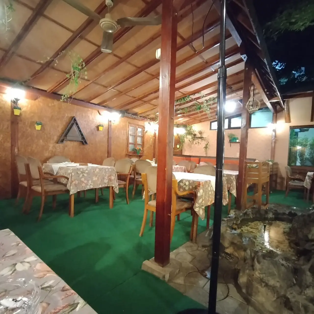 Natkrivena bašta restorana sa drvenim gredama